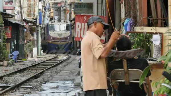 Train advancing through a densely populated lane in Hanoi, Vietnam