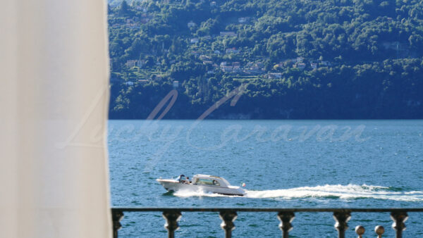 View from a balcony overlooking Lake Como with passage of a luxury boat