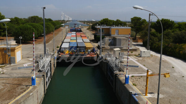 Container barge progressing through a lock in Port Saint Louis du Rhône, Camargue, southern France