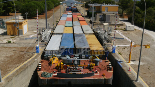 Container barge progressing through a lock in Port Saint Louis du Rhône, Camargue, southern France