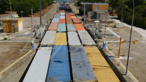 Container barge progressing through a lock in Port Saint Louis du Rhône, Camargue, southern France