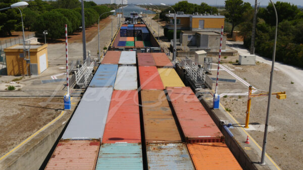 Container barge progressing through a lock in Port Saint Louis du Rhône, Camargue, southern France