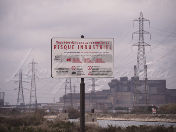 Industrial risk signage next to a factory.