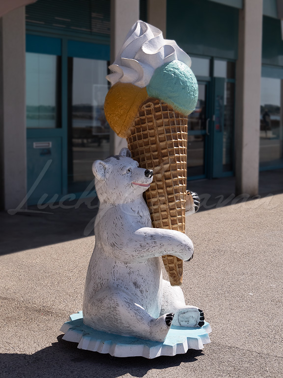 Polar bear with a giant ice cream cone in an urban environment in summer.