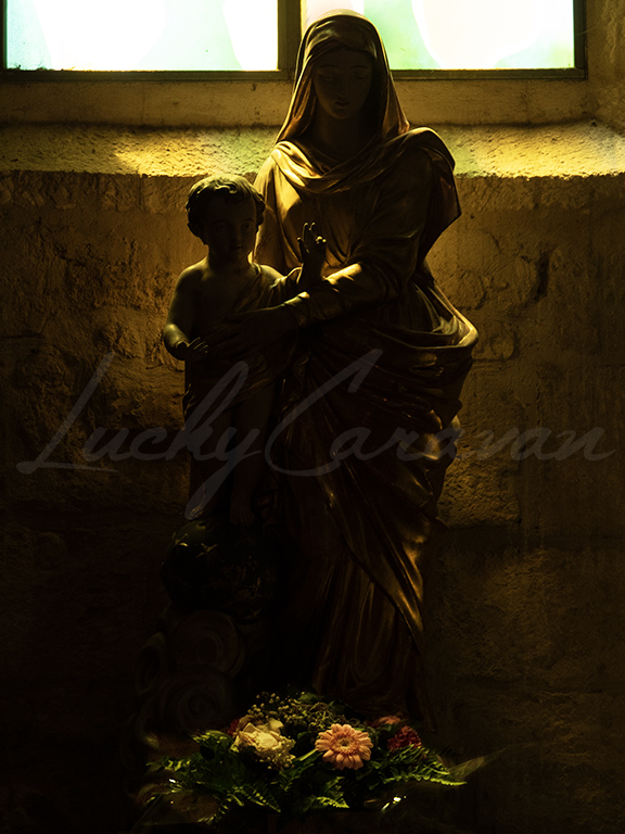 Statue of Virgin and Child in subdued golden light