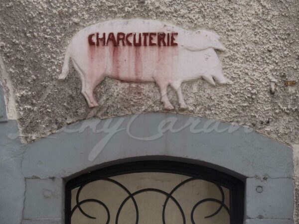 Pediment with pig on the facade of an old abandoned delicatessen