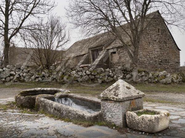 Old stone water trough in Rieutort d'Aubrac, on the Via Podiensis, one of the pilgrimage routes to Santiago de Compostela, Lozère, France