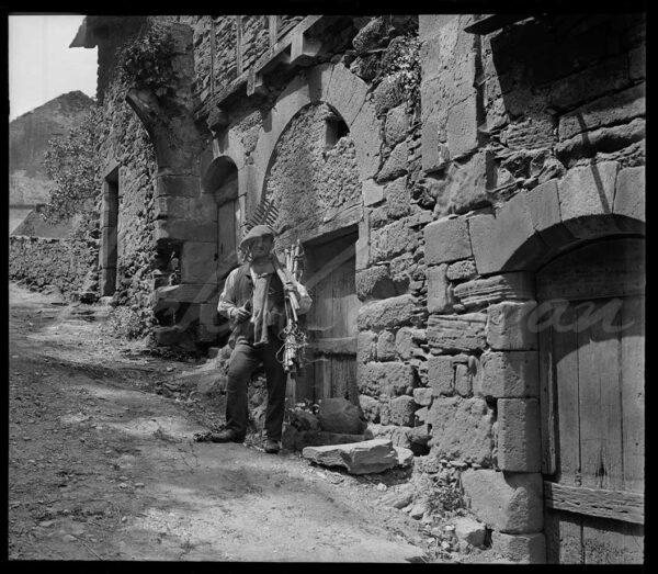 Peasant and tools in the dilapidated sector of a French village, circa 1900.