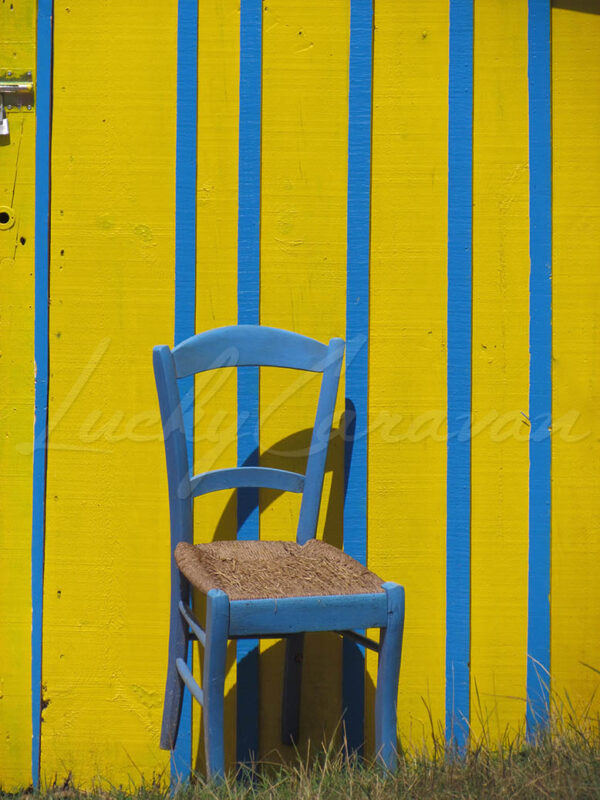 Blue chair on a blue and yellow wooden shed