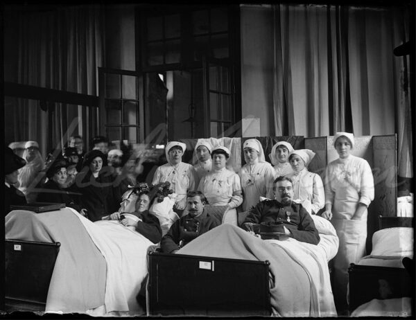 Wounded soldiers surrounded by nurses and their families in a hospital at the beginning of the First World War.