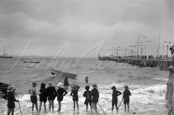 Children on the beach overlooking Arcachon Bay and its jetty, circa 1900.