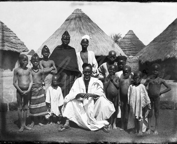 African family among their huts in a village in Guinea, circa 1900.