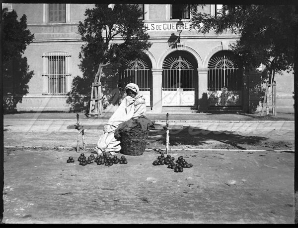 A fruit and vegetable seller in a square in the center of Algiers, Algeria, early 20th century.