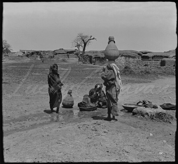 Palestine. Bedouin women at a waterwell outside a stone village, 1920–30.