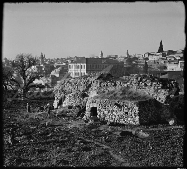 Palestine. Children playing in front of a makeshift dwelling in Jerusalem around the beginning of the 20th century. In the background is the secondary school which, for a time, in one of its rooms, housed the Imperial Museum of Antiquities and later, under the British Mandate, the Palestinian Museum of Antiquities.